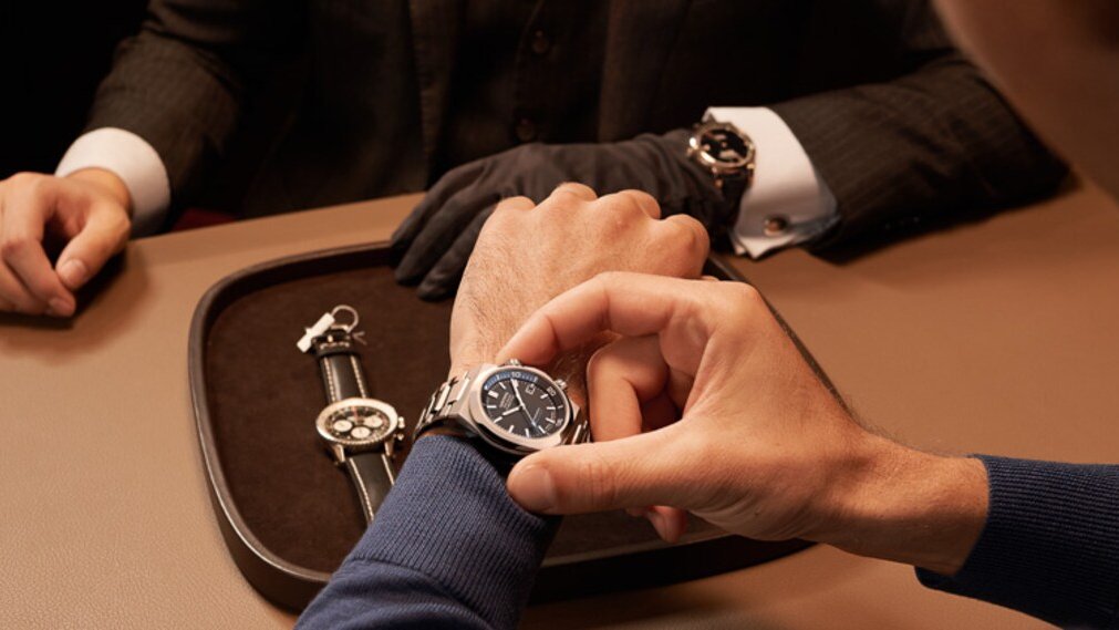 Customer receiving premium service while trying on a luxury wristwatch at an elegant boutique counter